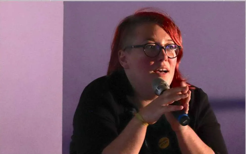 Emi au micro pendant sa conférence gesticulée