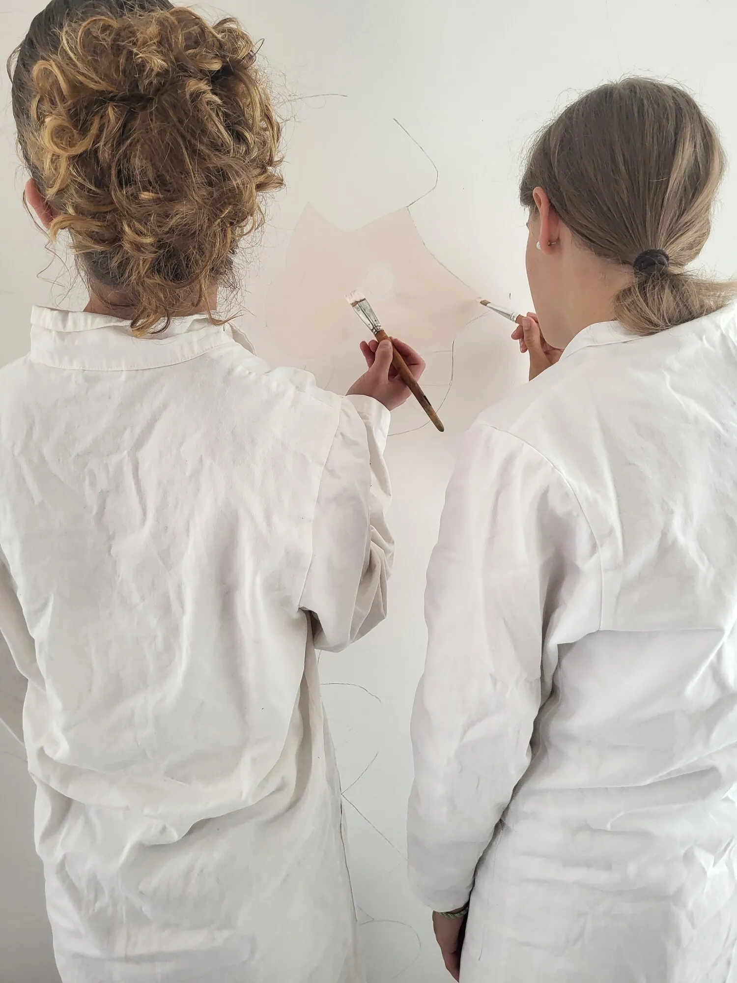 Deux participantes peignent la fresque