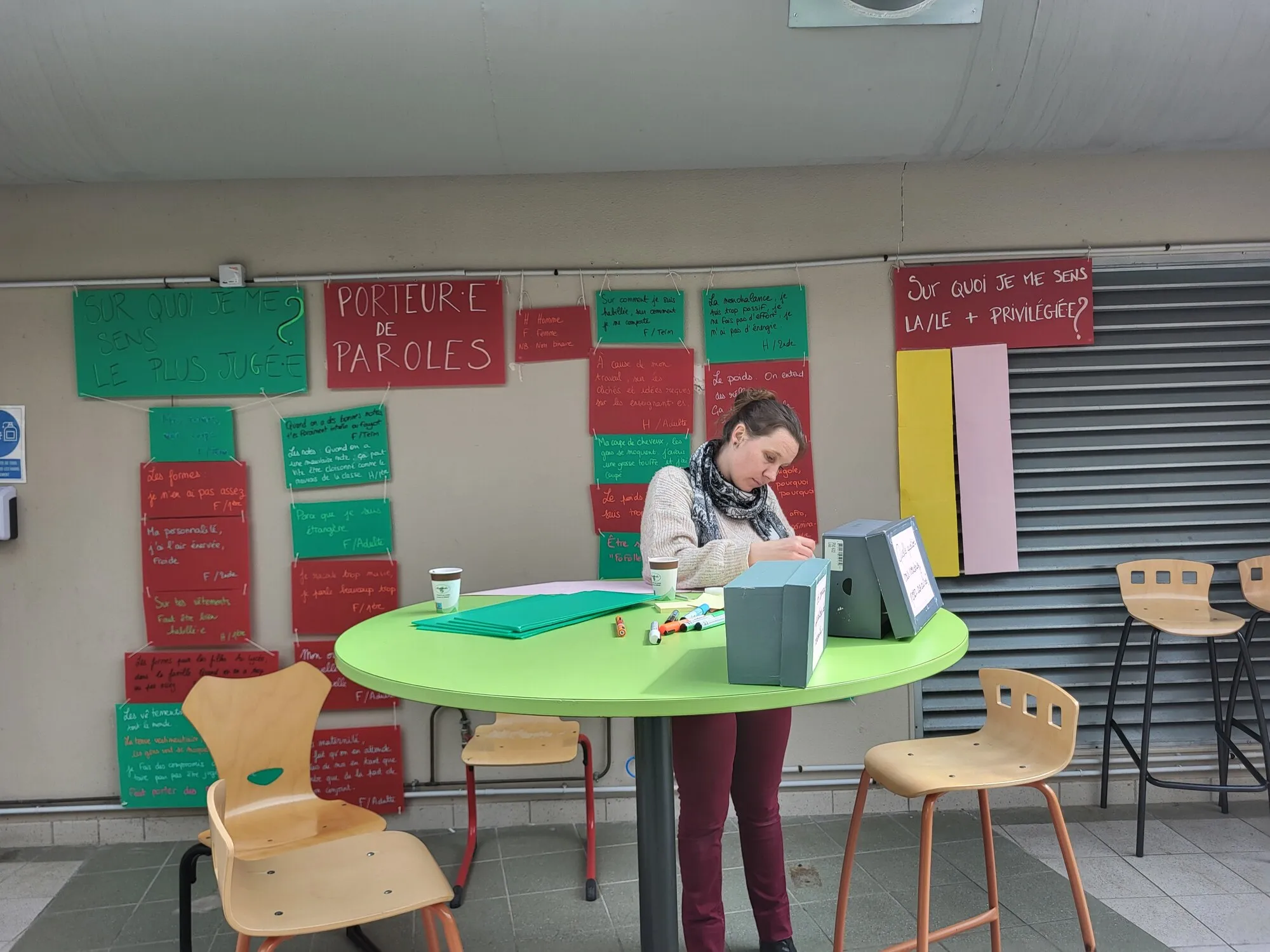 Une intervenante installe le porteur·euse de paroles dans le hall du lycée